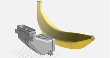 Imate of our Design for Manufacturing tool, with the banana shown for scale next to the part, which was invented during one of our innovation sprints