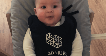 A baby wearing a bib with the DTSS-3D logo on it